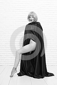 Funky style beauty. Sensual woman in fashion style on white brickwall. Fashion model wearing orange wig hair style and