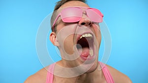 Funky stylish handsome guy in pink sunglasses. Punk is not dead. man freak screaming and making noise