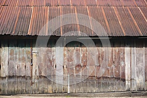 Funky wooden building with rusty corrugated metal roof in rural Laos