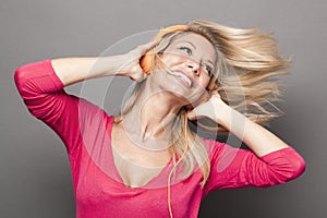 Funky young woman thrilled at good vibes with headphones on