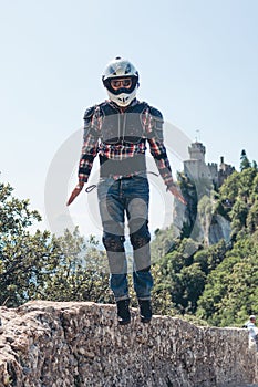 Funn jump like iron man Man dressed in a motorcycle outfit and white helmet. body protection turtle and knee pads. Fortress on