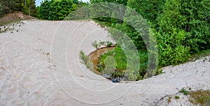 The funnel is formed by a white dune and a river.