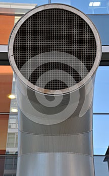 Funnel shaped ventilation duct on a modern building with mesh