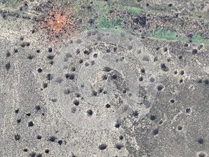 Funnels from artillery explosions cannon shells on the ground: top view drone shot. Ground Surface is covered with shell photo