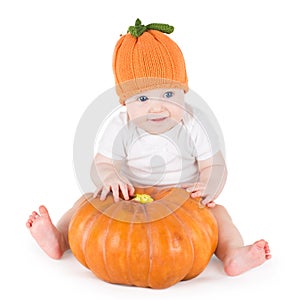 Funny adorable little baby playing with big pumpkin