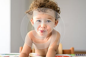 Funny adorable little girl with humorous expression during meal