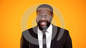 Funny african-american male in formalwear laughing cheerfully, joke and humor