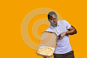Funny african bearded courier points to pizza. Big discount for customers. Tasty food pizza delivery from restaurant