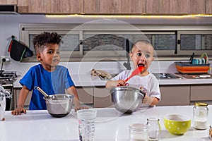 Funny african and caucasian kids in the kitchen. Buenos Aiores, Argentina photo