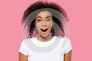Funny african female wearing glasses makes big eyes looking at camera