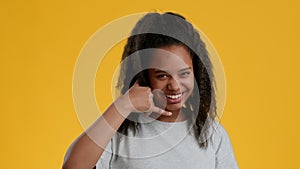 Funny African Teenager Girl Showing Call Me Gesture, Yellow Background