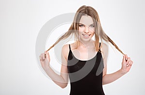 Funny amusing pretty young woman playing with hair