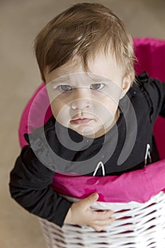 Funny angry baby girl in basket