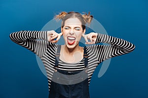 Funny angry woman with closed eyes covered ears by fingers