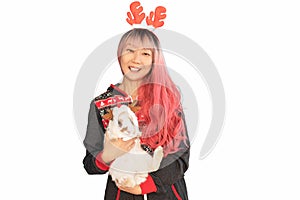 funny Asian girl in a Christmas reindeer antlers holding bunny smiling isolated on white background