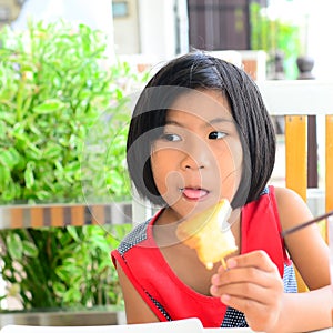 Funny Asian girl eating tasty bread