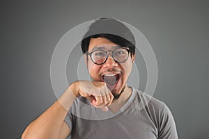 Funny Asian man is whipping his mouth.