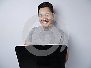 Funny Asian Man Working on His Laptop, Smiling Expression