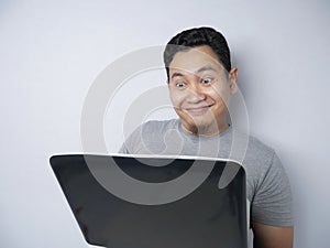 Funny Asian Man Working on His Laptop, Smiling Expression