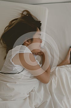 Funny Asian woman falls asleep with her mobile phone next to her