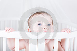 Funny baby biting on a crib