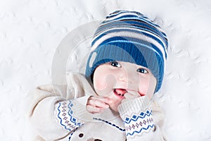 Funny baby in blue knitted hat and warm sweater