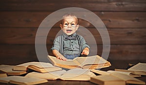 Funny baby with books in glasses