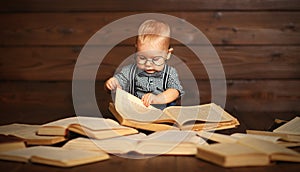 Funny baby with books in glasses