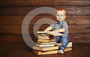 Funny baby with books in glasses