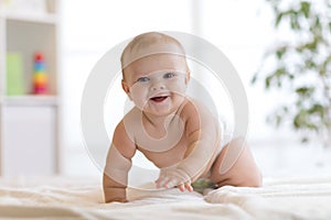 Funny baby boy crawling on bed at home