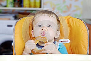 Funny baby boy eating round cracknel photo