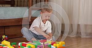 Funny baby boy with educational toy blocks.