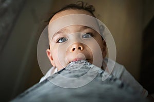 Funny baby boy playing with mom. Toddler looks to his mom