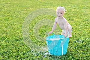 Funny Baby Boy Playing Outside with Water and Bubbles