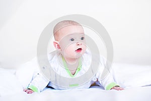 Funny baby boy playing under a white blanket