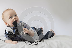 Funny baby boy singing karaoke. Lying infant kid with microphone and headphones. Concept for advertising of karaoke club
