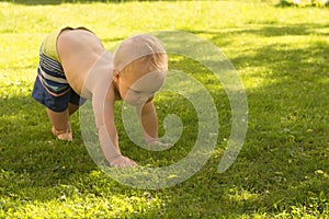 Funny baby boy toddle outdoor on the lawn