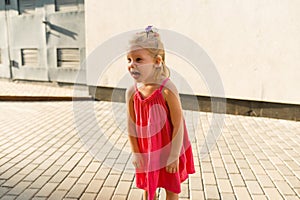 Funny baby with cochlear implant walks outdoor. Hearing aid and medicine innovating technology concept. Diversity and