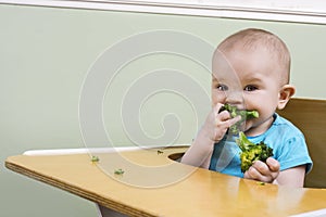 Funny baby eating broccoli
