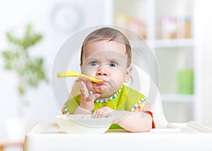 Funny baby eating food on kitchen