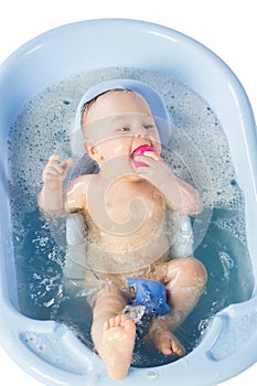 Funny baby girl bathes in a bathtube with