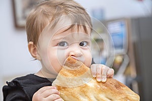 Funny baby girl eating bread