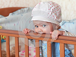 Funny baby girl in hat standing