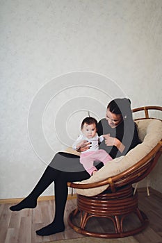 Funny baby girl with mother at home.