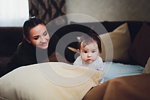 Funny baby girl with mother at home.