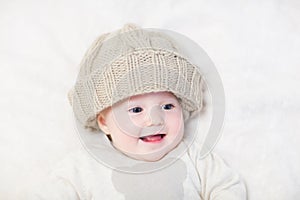 Funny baby in a huge knitted hat