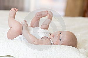 Funny baby infant girl playing with her feet