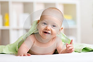 Funny baby kid under towel after bath