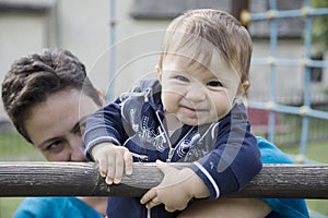 Funny baby looking at camera while mother holding and looking at her