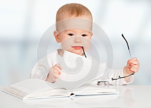 Funny baby reading a book